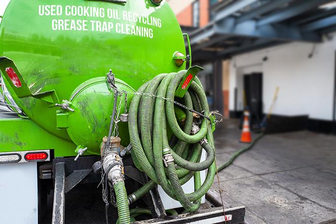 a grease trap being pumped by a sanitation technician in Tustin